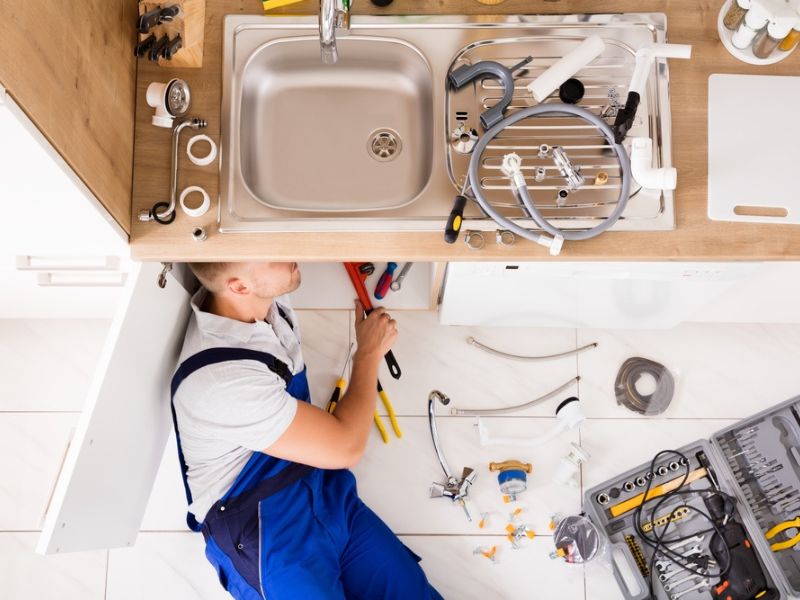 Plumber working on residential plumbing